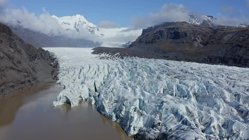 Aerial view of the ice of a glacier on a valley in the mountains