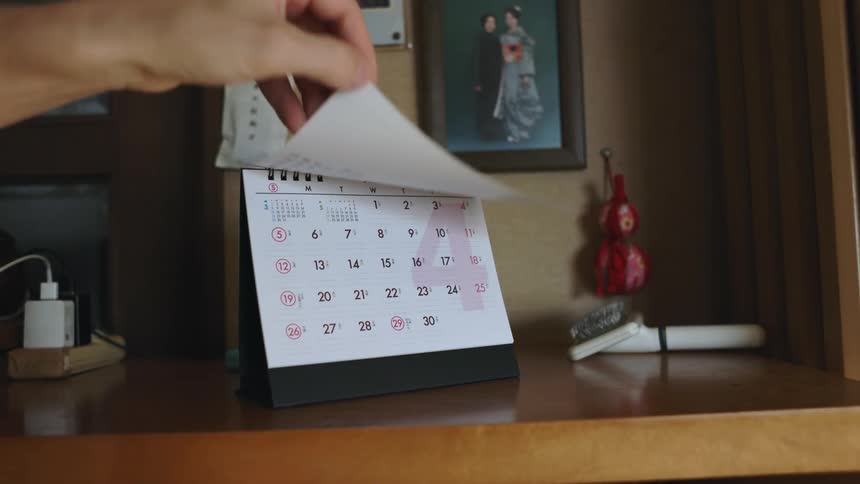 Person changes month on desk calendar