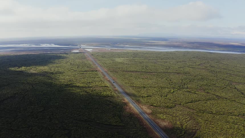 A lone car drives down the highway
