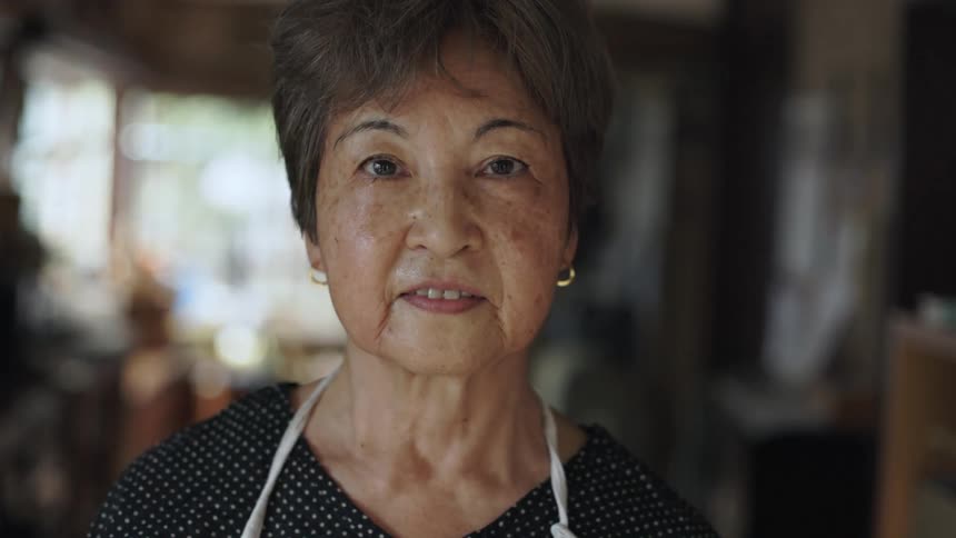 A woman wearing an apron over her shirt is looking ahead