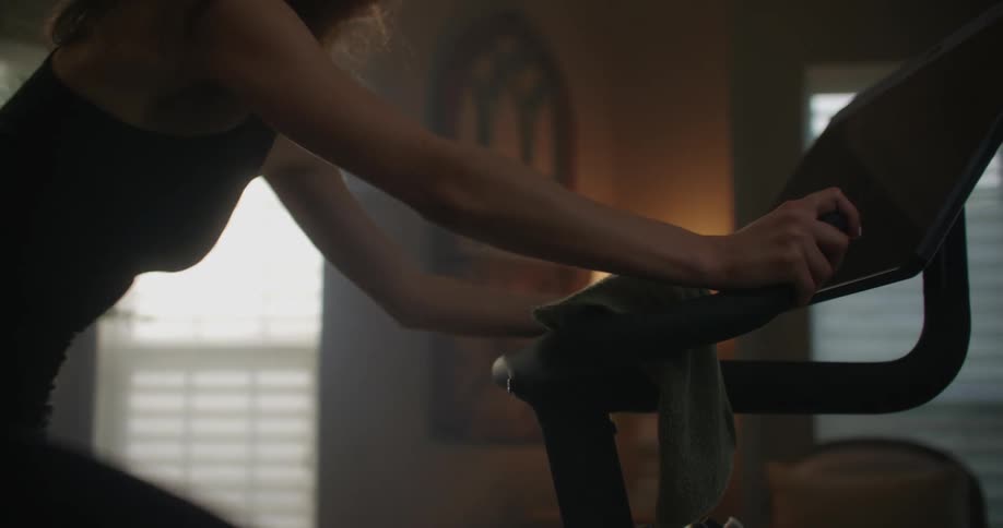 A woman exercising on a stationary bike at home