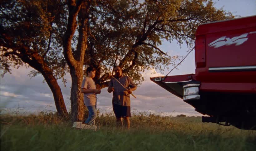 A father is showing his son a fishing pole