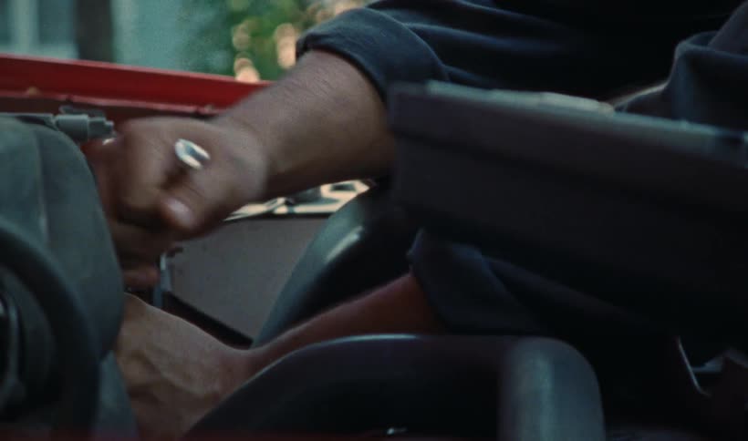 A man is wrenching on a car outdoors
