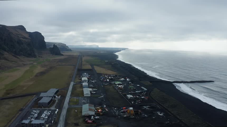 Aerial view of a small coastal town near a beach next to the ocean at daytime