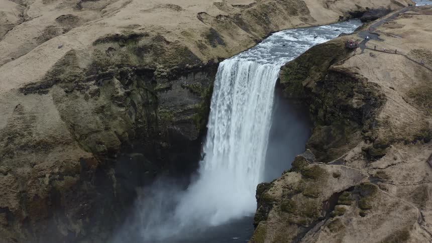 Aerial view of a powerful waterfall flowing down rocky slopes