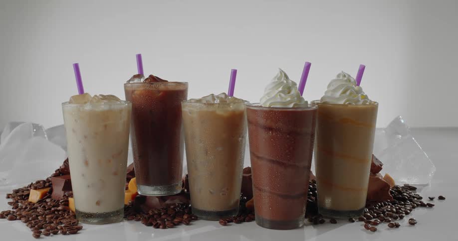 Chocolate wedges and coffee beans surround icy drinks with ice chunks in the back