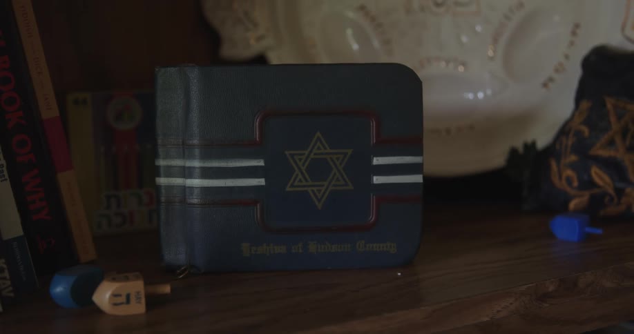 A wooden dresser with wooden toys and a book on it with a blue cover and a star on it