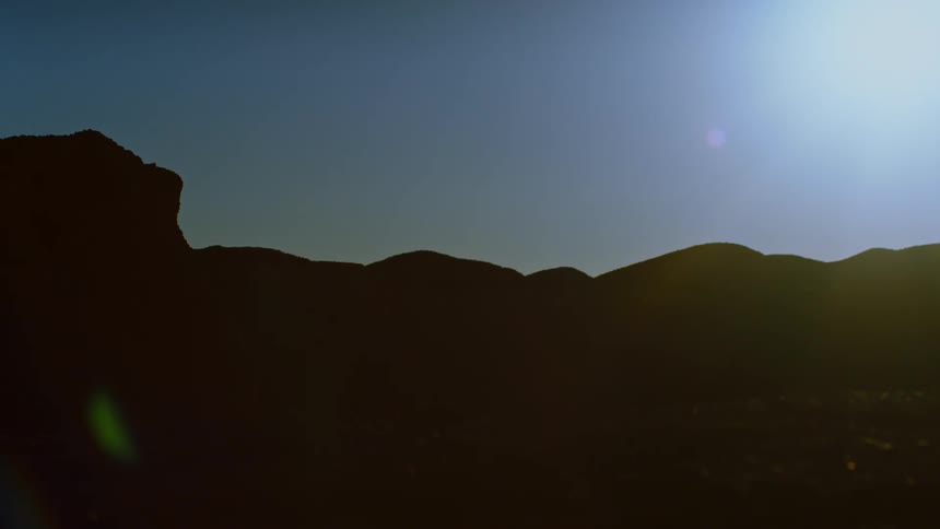 Landscape of mountain range being silhouetted against the shining sun