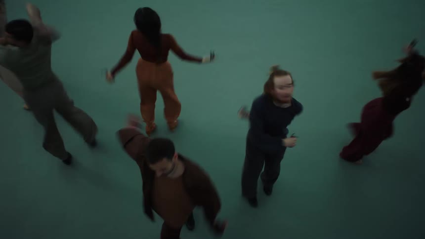 A group of men and women standing close together then breaking apart and each person twirling around