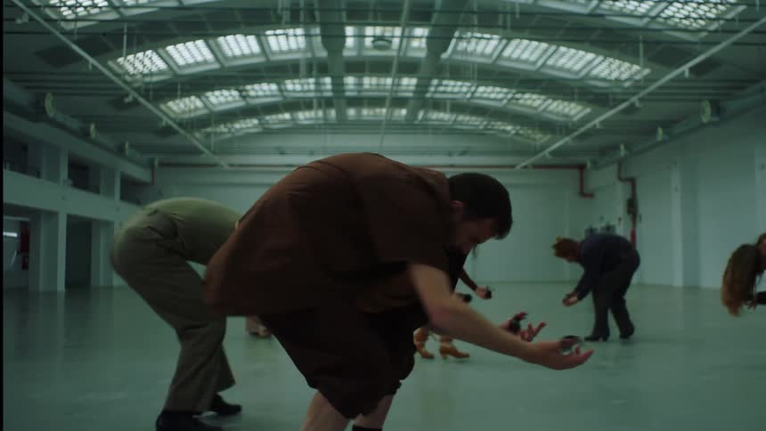 Group of interpretative dance performers dancing on a large empty hall