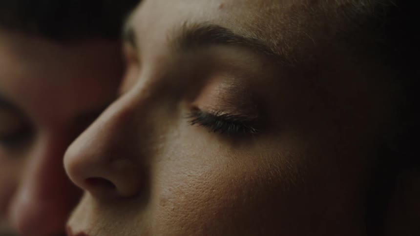 A close up of a womans face her eyes closed as she shakes