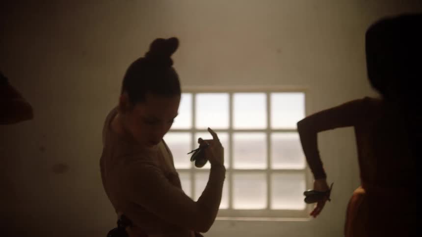 Female and male dancers dance in room while the sun shines through windows