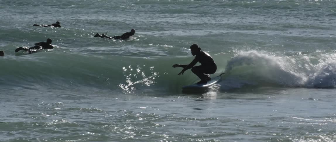 Surfer surfing on a low wave at the beach