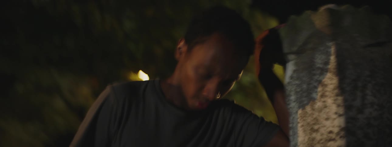 A man dancing around at night taking a break and catching his breath