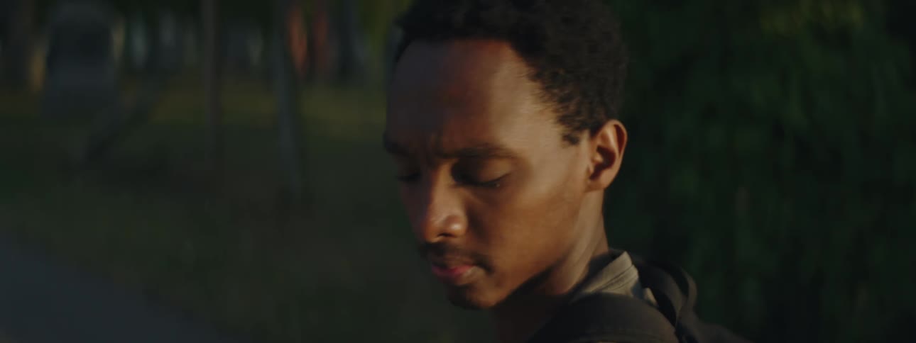 A black man turns to look over his shoulder then faces forward