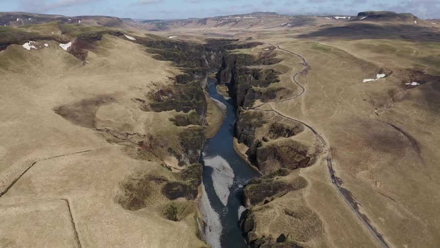 A rocky and sandy field with a divided path running through it