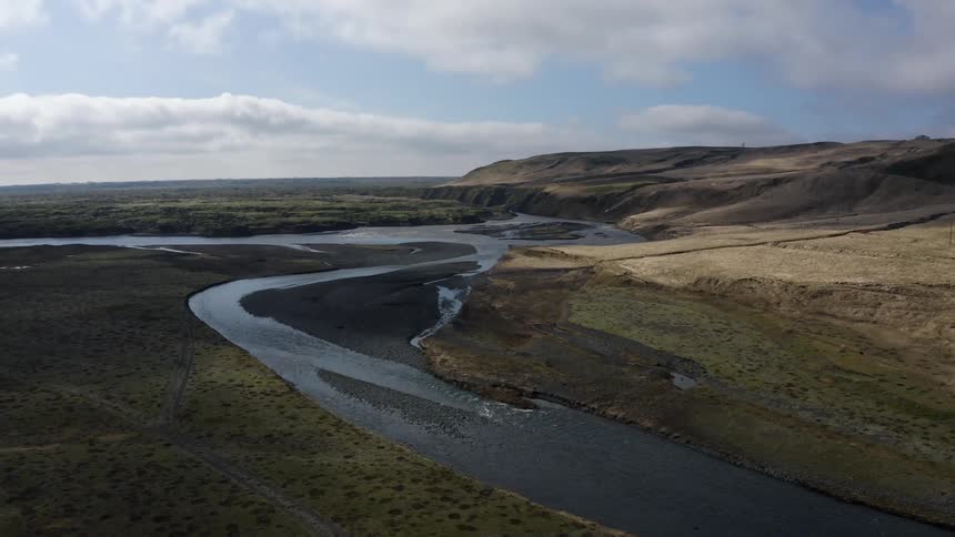 A river passes through a landscape full of subtle hills and slopes