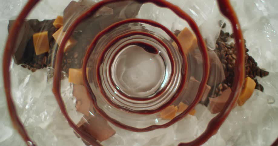 A close up and wide shot of chocolate swirls in a glass with ceramel and fudge chunks next to it