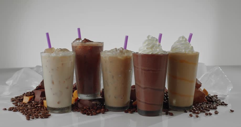 A parfait and ice cream served in a transparent cup placed on a grassy surface additionally there are chocolate particles scattered on the table adding a touch of indulgence