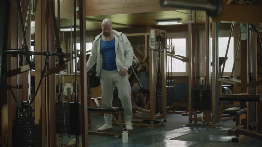A man sits down to lift weights in the gym
