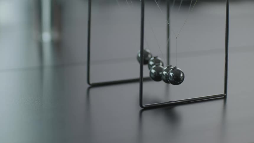 Metal ball on office desk toy sways slightly