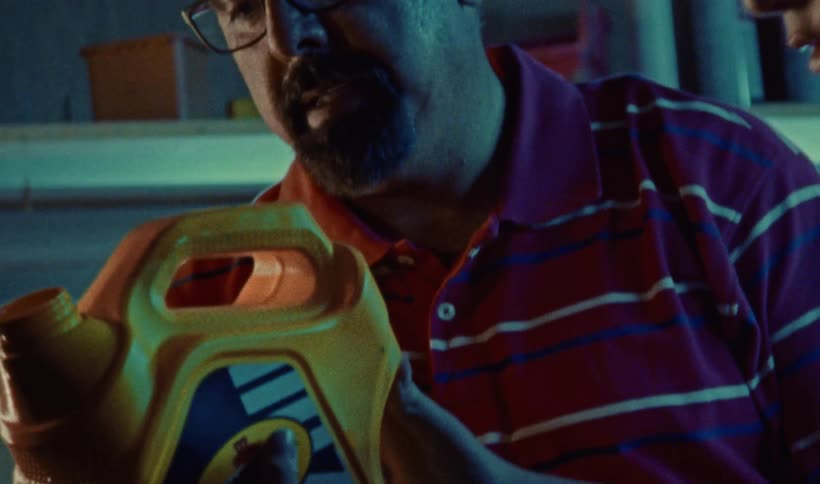 A father helping his teenage son pour out of a yellow canister