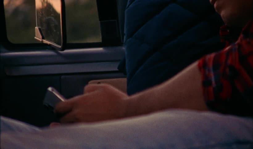 Man with red plaid shirt wakes up in vehicle in the morning