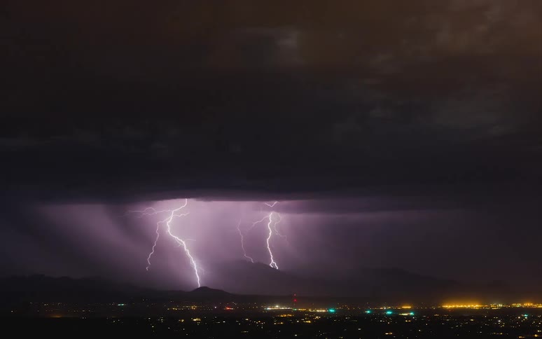 Lightning flashes in the sky above a city