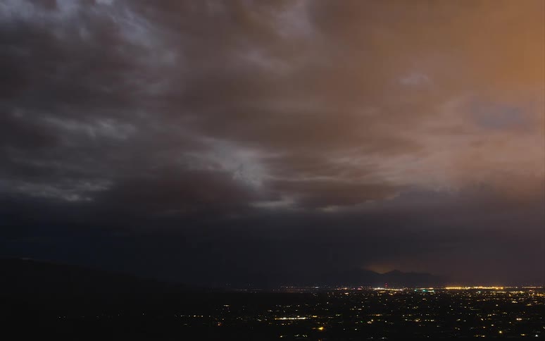 Lightning flashing and clouds flowing over city at night