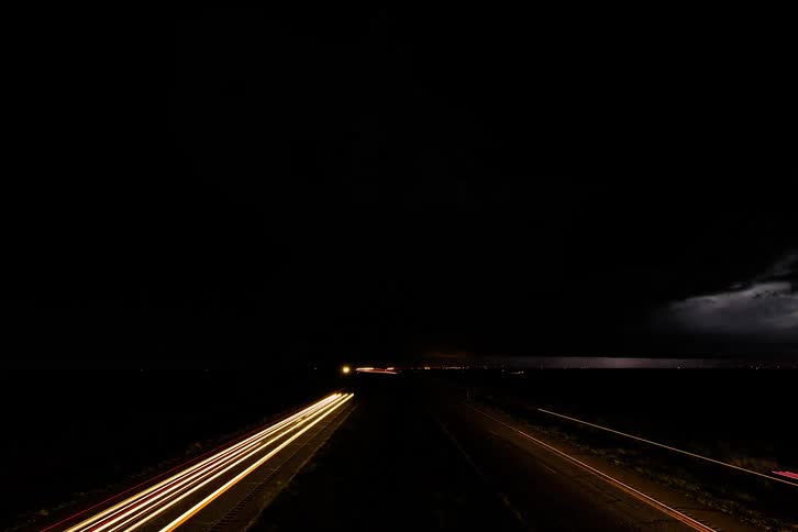 Time lapse of a storm over a highway at night