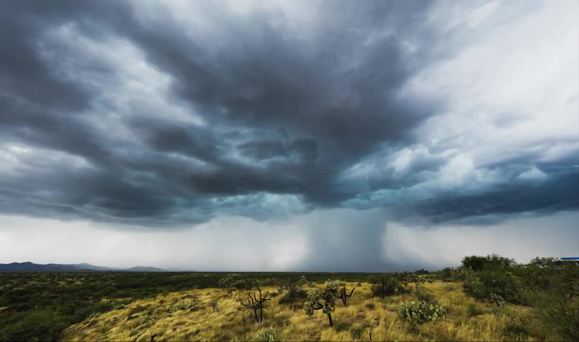 Time-lapse of dark clouds forming a wide tornado in an open  area