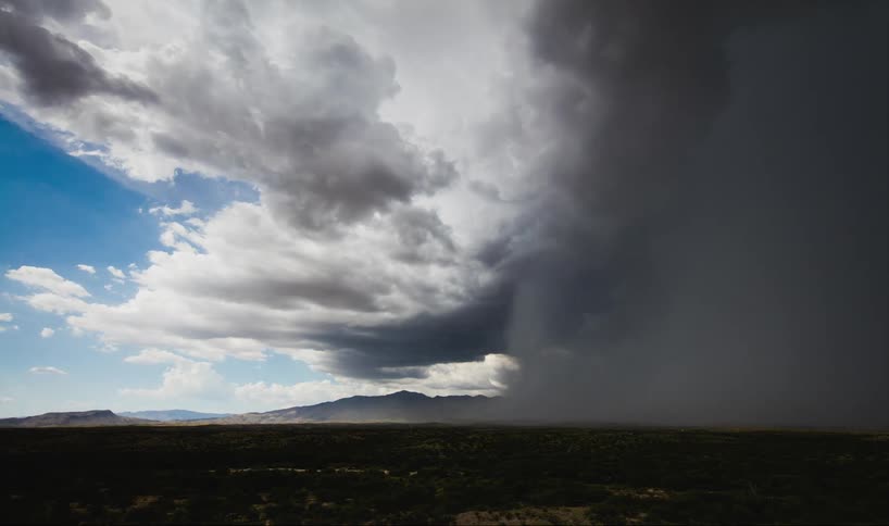 Time-lapse of a storm forming with a blue sky in the background