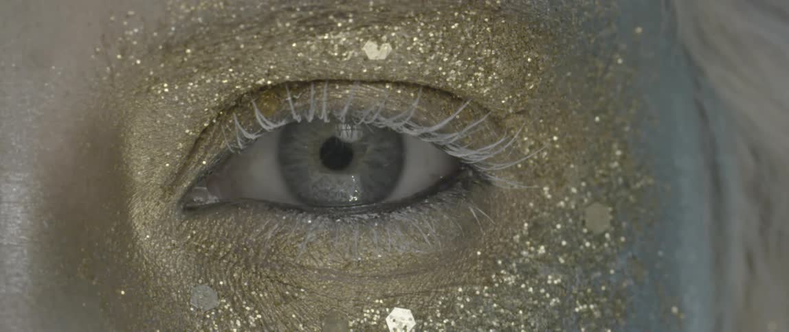 A person has gold glitter around their eye