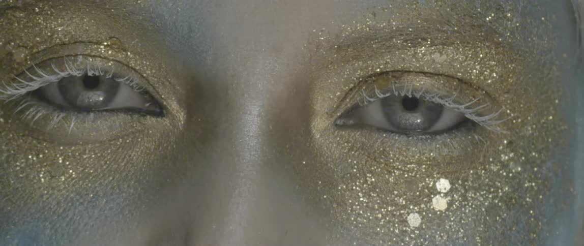 A person has gold glitter around their eyes
