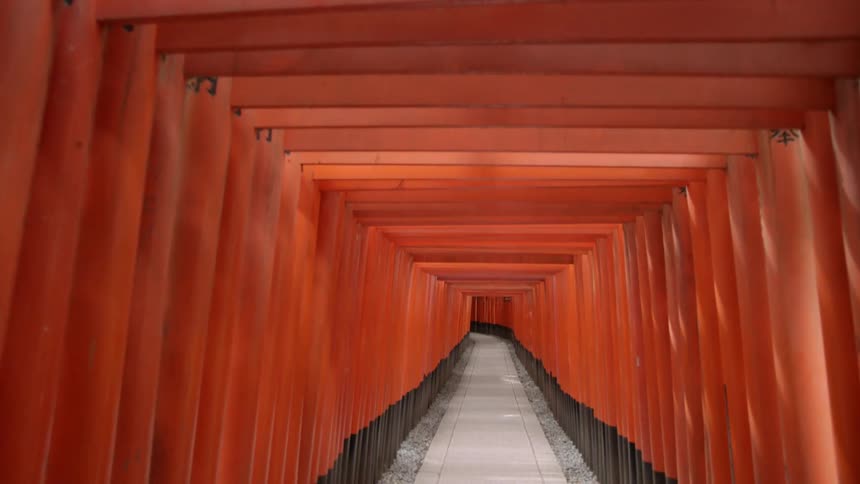 Square, red arches line a pathway in daylight