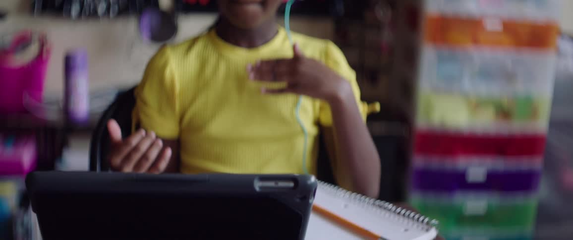 Girl wearing headphones learn sign language on a laptop