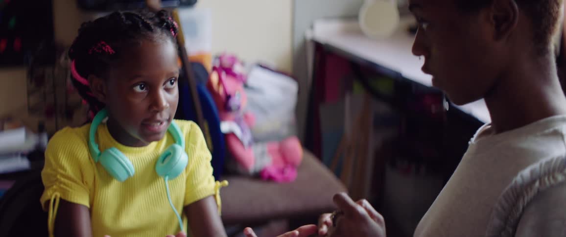 A mother and daughter are counting fingers doing school work at home