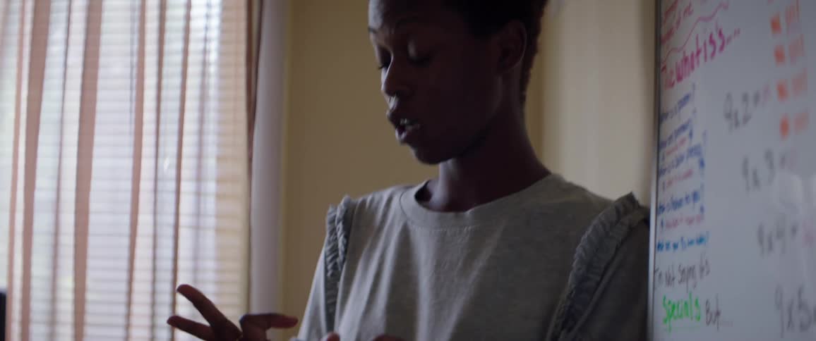 Young teacher in front of a whiteboard is homeschooling a girl