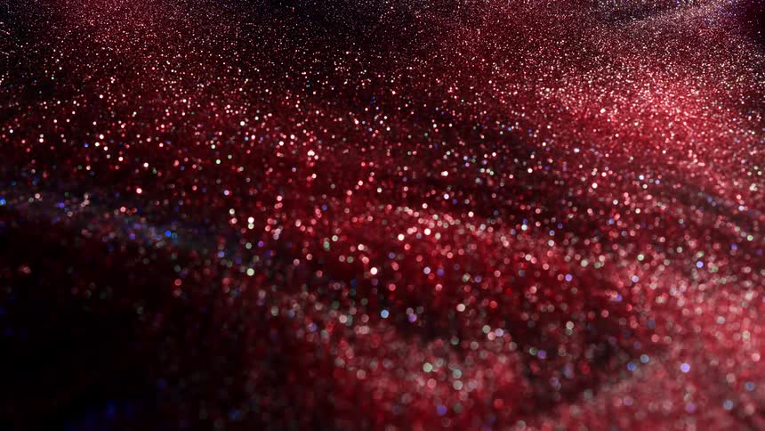 Slow wave of shimmering red glittering ink flowing right