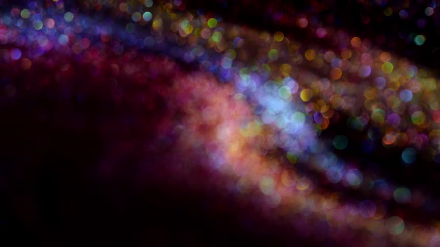 Out of focus close up of a surface covered in colorful shiny glitter