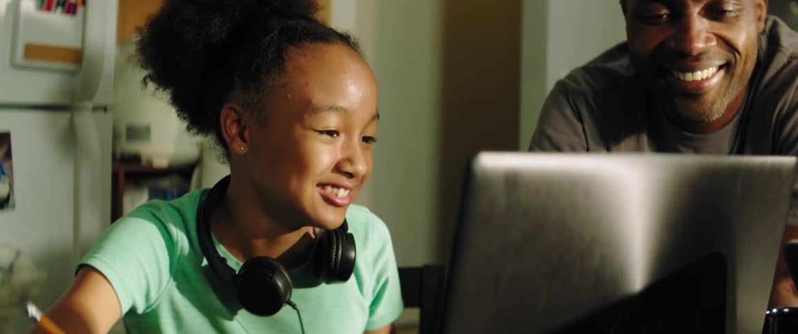 A father works on schoolwork with his daughter