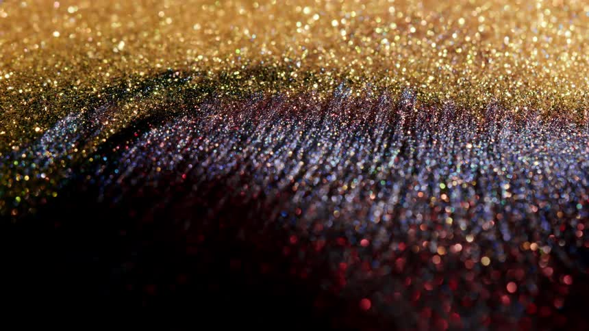 Shimmering bright colorful gold and red glitter moving and flowing slowly