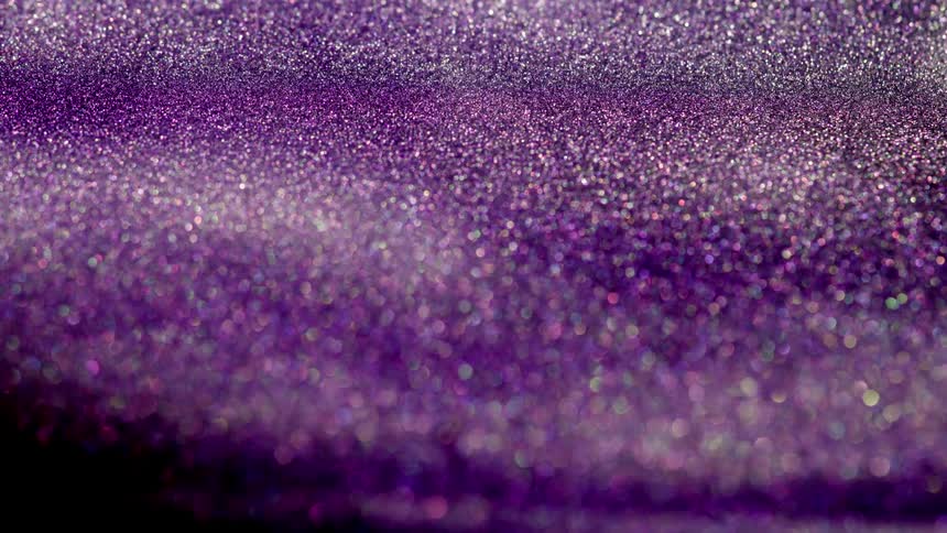 Shimmering bright colorful purple glitter moving and flowing slowly