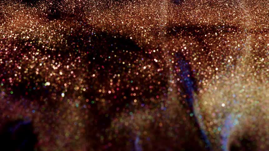 Gold sparkles twinkle as the substance moves