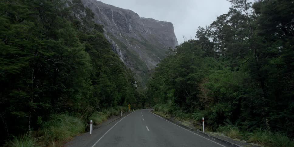 A small road leads to a tall mountain