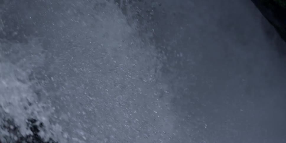 Water rages fast past some rocks