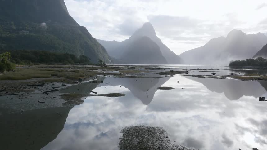 The water leads to tall mountains ahead
