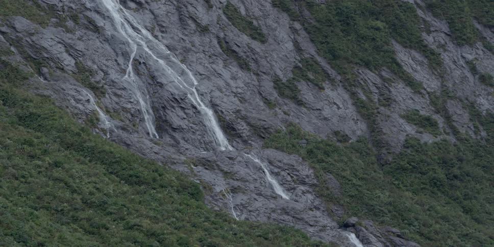 Thin streams of water flowing down a mountainside