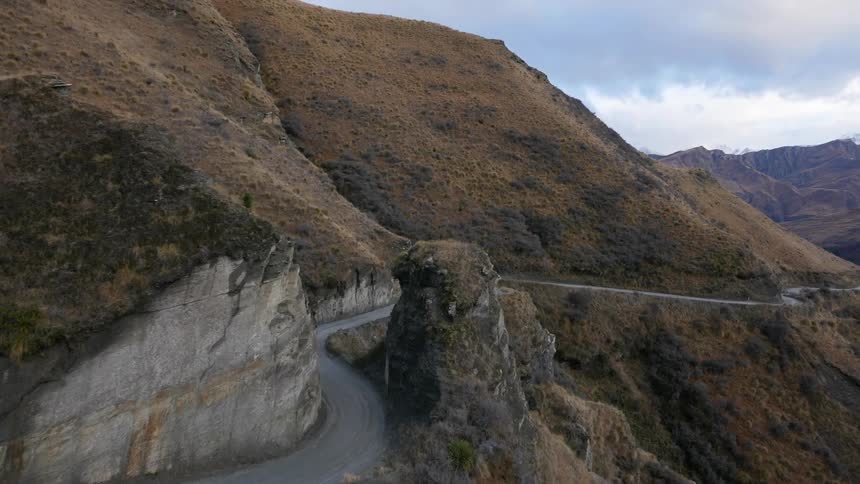 A small road is on the side of a mountain range