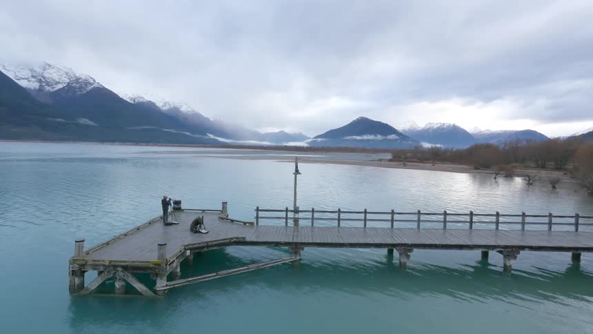 People are setting up cameras on the pier below